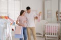 Happy pregnant woman with husband choosing baby clothes in store. Shopping concept Royalty Free Stock Photo