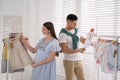 Happy pregnant woman with husband choosing baby clothes in store. Shopping concept Royalty Free Stock Photo