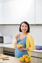 Happy pregnant woman on kitchen making healthy salad Royalty Free Stock Photo