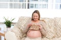 Happy pregnant woman knitting in the living-room Royalty Free Stock Photo