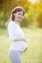 Happy pregnant woman on late pregnancy period walking in park Royalty Free Stock Photo