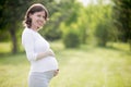 Happy pregnant woman on late pregnancy stage posing in park Royalty Free Stock Photo