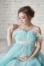 Happy Pregnant woman in long evening dress touching belly hands. Waiting the birth of a child, a woman in her eighth month Royalty Free Stock Photo