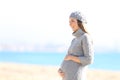 Happy pregnant woman looking away in winter on the beach Royalty Free Stock Photo