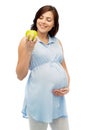 Happy pregnant woman looking at green apple Royalty Free Stock Photo