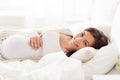 Happy pregnant woman lying on bed at home Royalty Free Stock Photo