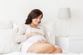 Happy pregnant woman lying on bed at home Royalty Free Stock Photo