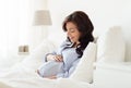 Happy pregnant woman lying on bed at home Royalty Free Stock Photo