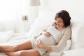 Happy pregnant woman lying on bed at home Royalty Free Stock Photo