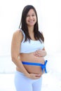 Happy pregnant woman measuring her tummy and waist. Royalty Free Stock Photo