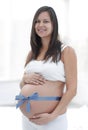 Happy pregnant woman measuring her tummy and waist. Royalty Free Stock Photo