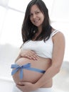 Happy pregnant woman measuring her tummy and waist. Royalty Free Stock Photo