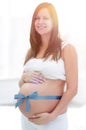 Happy pregnant woman measuring her tummy and waist. Royalty Free Stock Photo