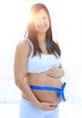 Happy pregnant woman measuring her tummy and waist. Royalty Free Stock Photo