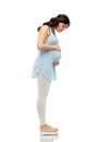 Happy pregnant woman measuring weight on scales