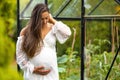 Happy pregnant woman outdoor in her garden looking down on belly Royalty Free Stock Photo