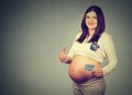 Happy pregnant woman with pills giving thumbs up Royalty Free Stock Photo