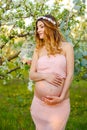 Happy pregnant woman in pink dress looking at sunrise.Pregnancy. Royalty Free Stock Photo