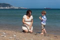 Happy pregnant woman playing with child boy on the beach Royalty Free Stock Photo