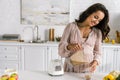 Pregnant woman pouring tasty smoothie in glass Royalty Free Stock Photo