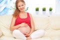 Happy pregnant woman is resting at home on sofa Royalty Free Stock Photo