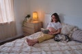 Happy pregnant woman resting while reading a book in the evening bedroom Royalty Free Stock Photo