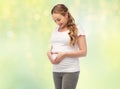 Happy pregnant woman showing heart gesture