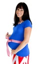 Happy pregnant woman showing off her belly with a pink bow Royalty Free Stock Photo