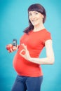 Happy pregnant woman showing sign ok, holding apple and glucometer with good result sugar level Royalty Free Stock Photo