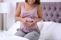 Happy pregnant woman sitting on bed at home Royalty Free Stock Photo