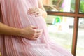 Happy pregnant woman sitting on chair at home. Royalty Free Stock Photo