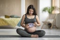 Happy Pregnant Woman Sitting On Yoga Mat And Holding Baby Sonography Scan Royalty Free Stock Photo