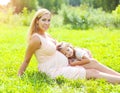 Happy pregnant woman, smiling mother and child lying on grass in summer Royalty Free Stock Photo