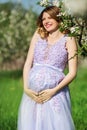 Happy pregnant woman in spring blossom garden Royalty Free Stock Photo