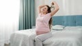 Happy pregnant woman stretching out hands after waking up at morning. Concept of happiness during pregnancy and