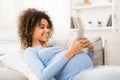 Happy pregnant woman surfing the net on smartphone Royalty Free Stock Photo