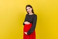 Happy pregnant woman touching her abdomen at Colored background. Future mother is wearing white underwear. Expecting of Royalty Free Stock Photo