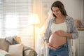 Happy pregnant woman touching her belly indoors Royalty Free Stock Photo