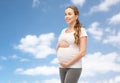 Happy pregnant woman touching her belly over sky Royalty Free Stock Photo