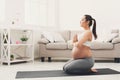 Happy pregnant woman training yoga in hero pose Royalty Free Stock Photo