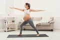 Happy pregnant woman training yoga in hero pose Royalty Free Stock Photo