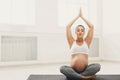 Happy pregnant woman training yoga in lotus pose Royalty Free Stock Photo