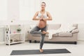 Happy pregnant woman training yoga in tree pose Royalty Free Stock Photo