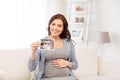 Happy pregnant woman with ultrasound image at home Royalty Free Stock Photo