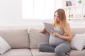 Happy pregnant woman using digital tablet. Royalty Free Stock Photo