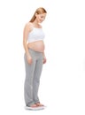 Happy pregnant woman weighting herself Royalty Free Stock Photo