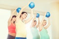 Happy pregnant women exercising with ball in gym