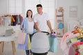 Happy pregnant woman with husband choosing baby stroller in store. Shopping concept Royalty Free Stock Photo