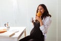 Happy pregnant young beautiful woman eating croissant during morning breakfast. Concept of pleasant morning and positive Royalty Free Stock Photo