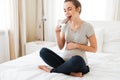 Happy pregnant young woman eating chocolate bar on bed Royalty Free Stock Photo